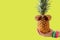 Summer and Holiday concept.Hipster hand holding Pineapple Fashion Accessories and Fruits on yellow background