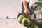 Summer and holiday fashion concept.Man Wearing palm trees graphics on T-shirt and holding cluster of coconuts with items on beach