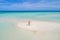 Summer holiday fashion concept - tanning girl wearing sun hat at the beach on a white sand shot from above.Top view from drone.