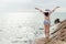 Summer Holiday. Lifestyle asian woman raise hands  and standing chill on rocks near sand beach