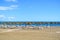 Summer holiday view of a Mediterranean beach prepared for a tourist season, a sandy beach by the blue sea, deckchairs