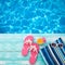 Summer Holidays in Beach Seashore. Fashion accessories summer flip flops, hat, sunglasses on bright turquoise board near the pool