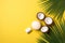 Summer holidays concept. Top view photo of white sunscreen bottle cream jars cracked coconuts and palm leaves on isolated yellow b