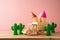 Summer holidays concept with toy truck, ice cream and cactus on wooden table over pink background