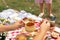 Summer holidays outdoor picnic. Woman hold the wooden honey spoon, honey drips from it to pot. Instagram content