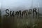 Summer inscription on the texture with condensation on the glass.