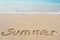 Summer inscription on a tropical sandy beach with blue see on a background.