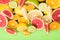 Summer juicy mix of citrus fruits on a bright green board