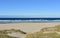 Summer landscape with Atlantic beach with waves breaking, grass in sand dunes and blue sky. Arteixo, CoruÃ±a, Galicia, Spain.