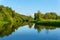 Summer landscape of a calm oxbow lake with wooded shores