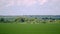 Summer landscape with field of grass, blue sky and clouds.