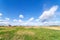 Summer landscape with green grass. Field and clouds. Rural summer landscape