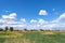 Summer landscape with green grass. Field and clouds. Rural summer landscape