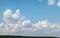 Summer landscape. Lots of sky, horizon line and a strip of forest. Upsized texture clouds. Background clouds