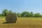 Summer landscape of a meadow with a bale of hay