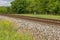 Summer landscape with railway, trees and wildflowers