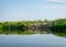 Summer landscape, river bank pollution, concrete blocks thrown into the river, reflections in the water