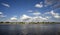 Summer landscape with river and clouds in the sky.