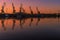 Summer landscape with river, motor boats and Silhouettes of cranes in the port.