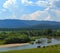 Summer landscape with river mountains and horses