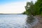 Summer landscape with a river and a rocky Bank with trees