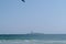 Summer landscape from the sea with kite surfer over the island