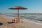 Summer landscape: table, benches and shade umbrella on the beach