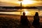 Summer landscape with young caucasian tourist friend watching golden sunset on tropical Khao Lak Beach in Phang Nga in Thailand