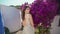 Summer model posing garden in windy dress closeup. Girl sniffing flowers aroma