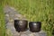 Summer mood with closeup of two unique handmade black pottery planters in sunlight before sunset