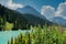 Summer mountain landscape with turquoise lake and wildflowers in the Swiss Alps