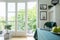 Summer nature view from a balcony outside a white dining room interior with a magazine and fruit on table