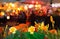 summer night city life yellow orange flowers on front cafe where people relaxing under tent blurred street lamp light in Tallinn