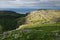 Summer norway landscape - granite high shore, green valley and blue quiet Arctic Ocean in sunny weather.