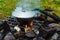 Summer outdoor rest. Camping in the forest in mountains. Cauldron on campfire. Cooking camp food