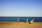 Summer is over. Umbrellas and a deckchair on a sunny empty beach without people