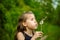 Summer in park or forest. nature, freshness idea freedom. happy childhood.Summer joy, little girl blowing dandelion at