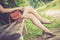 Summer in the park: Young woman in sexy black dress and ballerinas is sitting on a park bench