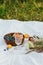 Summer picnic aesthetics. Tasty fruits and berries in bowl, wineglasses and bouquet of wildflowers