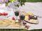 Summer picnic with cheese, flat bread, wine, fruits and bread.