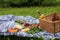 Summer picnic on the grass. Bottle of white wine, glasses, basket, fresh fruits, and vegetables, rice crackers. Healthy food