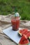 on a summer picnic on a white board on the shore of the lake, a watermelon cocktail