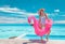 Summer pool fun swimsuit model posing in pink flamingo float showing off slim figure bikini ready body for luxury