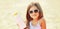 Summer portrait close-up little girl child on beach showing sunscreen skin bottle