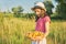 Summer portrait of girl in meadow with bowl of yellow sweet cherry