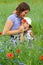 Summer portrait of happy cuddling mother and son in the blooming poppies field