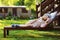 Summer portrait of happy kid girl relaxing on lounger in garden