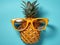 Summer portrait of a happy smiling pineapple lying on the beach. Generated by AI