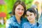 Summer portrait of mom and daughter in the park. On the background of blurry children`s slides