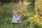 Summer portrait of sibling children are in old apple orchard